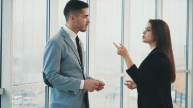 Two business people are talking in office, on the panoramaic blurred background. Close up. Copy space. 4K.