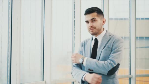 El hombre de negocios es serio con las manos cruzadas o dobladas mientras posa, aislado sobre fondo panorámico blanco. Copiar espacio. 4K . — Vídeos de Stock