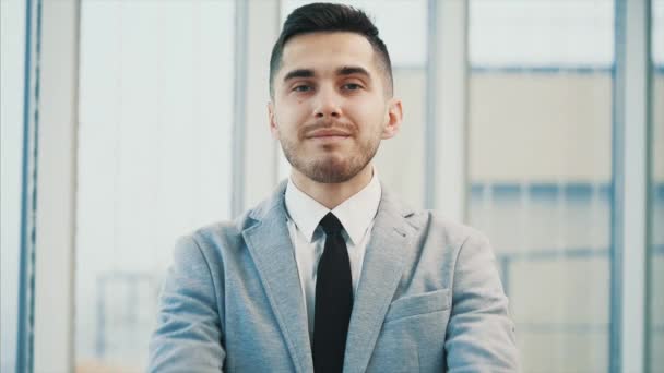 El hombre de negocios sonríe a la cámara con los dedos del pulgar hacia arriba, aislado sobre fondo panorámico blanco. De cerca. Copiar espacio. 4K . — Vídeos de Stock