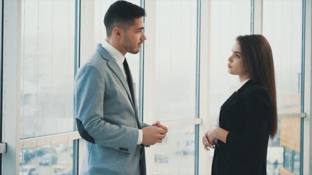 Two business people are talking in office, on the panoramaic blurred background. Close up. Copy space. 4K. — Stockvideo