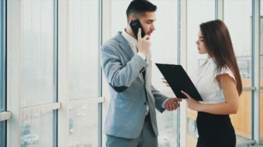 Başarılı bir takım. Uzayı kopyala Patron şu an telefonda. Belgeleri imzalıyor. Bulanık beyaz panoramik arka plan. Kapatın. 4k.