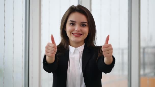 Mulher de negócios sorrindo para câmera com os dedos do polegar para cima, isolada em fundo panorâmico branco. Movimento lento. Fecha. Espaço para cópia. 4K . — Vídeo de Stock