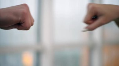 İki iş adamının yumruğu. Dost canlısı ortaklar ilk hamleyi yapıyor. Arka plan bulanık. Kapatın. Ağır çekim. Yavaş ol. 4K.