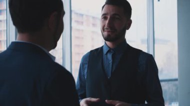 Erkek iş adamları sorunları tartışıyor. Uzayı kopyala Odaklanan adam nazikçe okşanıyor. Başarılı bir anlaşma. Arka plan bulanık. Kapatın. 4k.