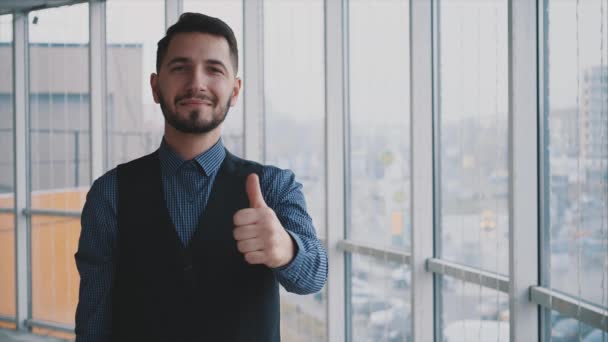 Udany biznesmen pokazuje kciuk w górę gestu, na tle jasnej panoramy. Odizolowany człowiek. Zwolnij trochę. Powolniak. 4k. — Wideo stockowe