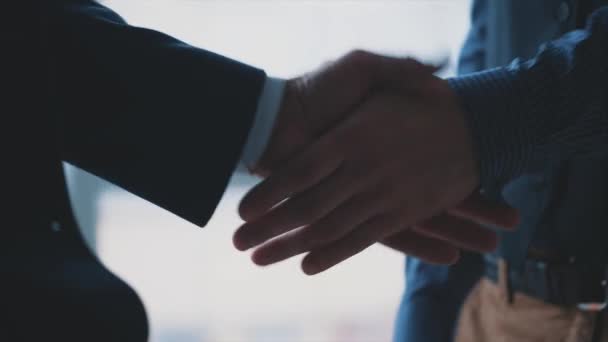 Handshake of two men. Friendly men are shaking hands. Business partners are handshaking. Blurred background. Close up. Slow motion. Slowmo. 4K. — Stock Video