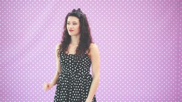 Engraçado encaracolado menina em bonito polka-dot vestido é cathing algumas coisas voando do ar . — Vídeo de Stock