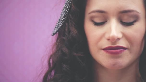 Cropped face of young lady with curly black hair and headband in polka-dots, biting off enticingly a piece of chocolate, enjoying its taste, closing her eyes. — Stock Video