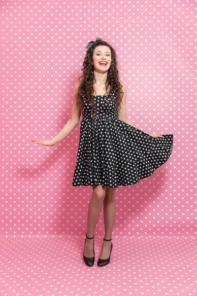 Stylowa i pewna siebie piękna dziewczyna ubrana w sukienkę polka-dot i opaskę, pozująca na tle polka-dot. — Zdjęcie stockowe