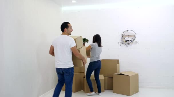 Casal está se divertindo transportando caixas em seu novo apartamento . — Vídeo de Stock