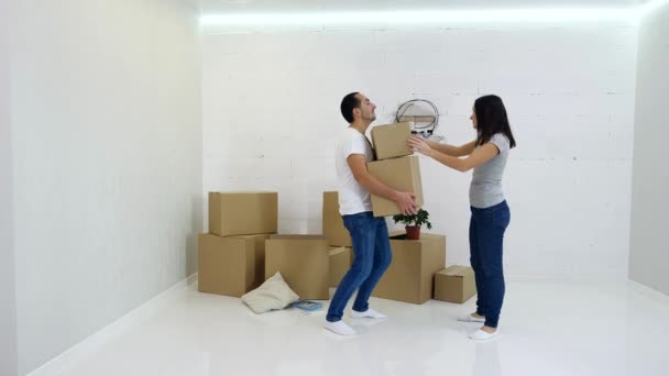 Casal jovem embalagem e realização de caixas de papelão de seu antigo apartamento . — Vídeo de Stock