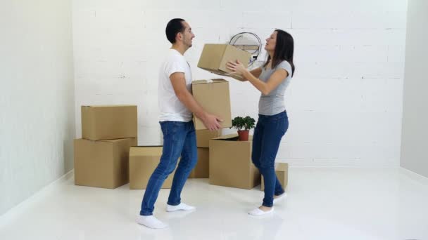 Νεαρό ζευγάρι συσκευασίας και μεταφοράς χαρτονένια κουτιά από το παλιό τους διαμέρισμα. — Αρχείο Βίντεο