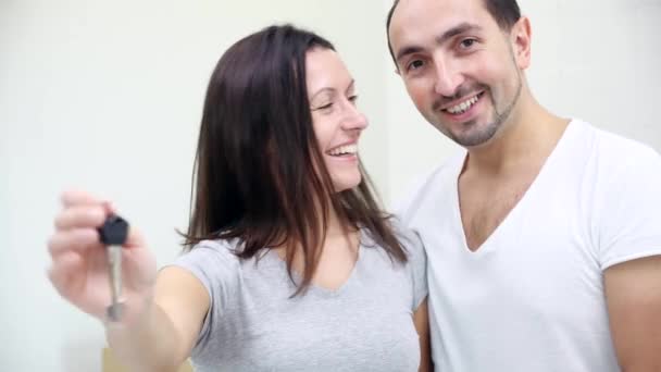 Close-up 4K videó boldog pár az új otthon, élvezi a jó vásárlás, mutatja a kulcsot a kamera. — Stock videók