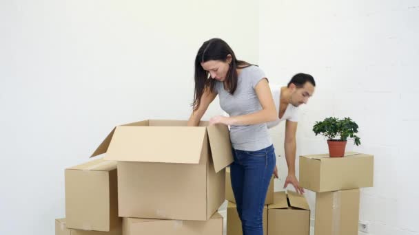 Paar uitpakken kartonnen dozen na verhuizing naar nieuw huis en kan niet vinden sommige bezittingen, op zoek geïrriteerd. — Stockvideo