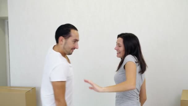 Affectueux jeune couple familial s'amuser et danser parmi les boîtes en carton dans leur nouvel appartement confortable . — Video