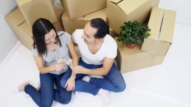 Yeni dairelerine taşınıp yeni kutuların yanında şampanya içen başarılı beyaz çiftin en iyi görüntüsü..