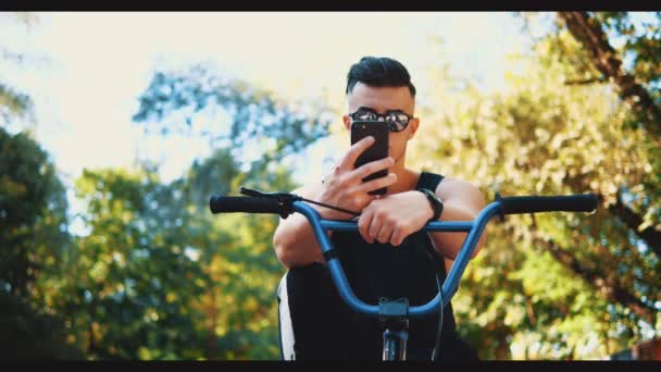 Close up man. Guy is using his phone, being in sunglasses. Copy space. 4K. — Stock Video