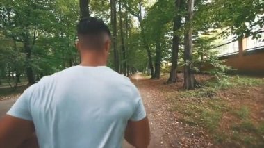 Erkekler parkta koşuyor, yarışmadan önce sabah egzersizleri yapıyor. Dikiz aynası. Kapatın. Uzayı kopyala 4K.