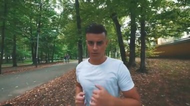 Erkekler parkta koşuyor, yarışmadan önce sabah egzersizleri yapıyor. Kapatın. Uzayı kopyala 4K.