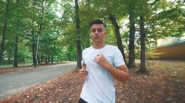 Erkekler parkta koşuyor, yarışmadan önce sabah egzersizleri yapıyor. Kapatın. Uzayı kopyala 4K.