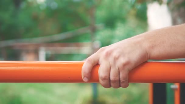 Primer plano del joven deportista haciendo ejercicio en las barras de paraller. Fondo borroso. Acción. 4K . — Vídeo de stock