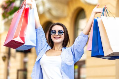 Büyük satış döneminde büyük alışveriş merkezlerinde çantaları olan moda kadını satın aldıklarını paylaşıyor..