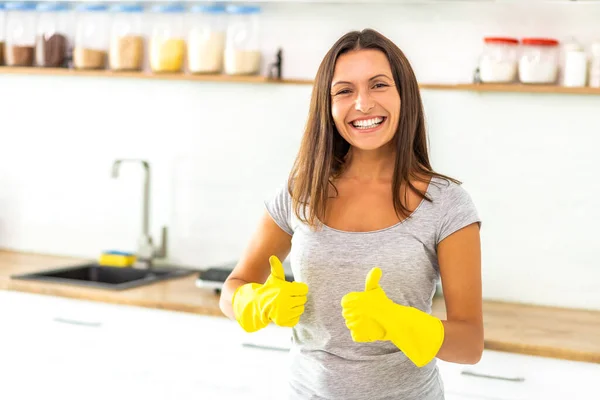 Determinata moglie in guanti gialli è pronta e desiderosa di iniziare a pulire la sua cucina moderna e dà pollici in su . — Foto Stock
