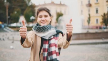 Sevimli kız parmaklarını meydanda gösteriyor, güvercinlerle dolu. Mavi arkaplan, parmaklar üzerinde odaklan. Ağır çekim. Uzayı kopyala 4K.