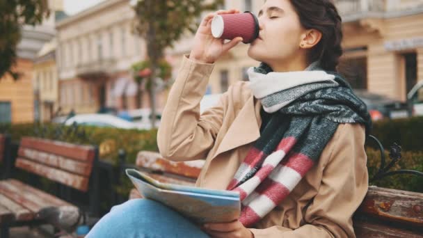 Una joven atractiva está bebiendo bebidas calientes, mientras está sentada en el banco. De cerca. Copiar espacio. 4K . — Vídeos de Stock