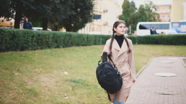 Adorabile e giovane turista con lunghe trecce nere sta vestendo uno zaino turistico e camminando. Chiudete. Ricevuto. 4K . — Video Stock
