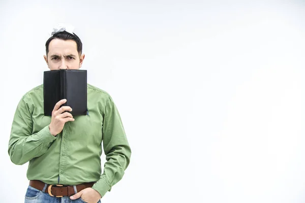 Hombre de negocios maduro mirando sobre el cuaderno negro con expresión facial sospechosa y desconfiada sobre fondo blanco con espacio para texto o producto . — Foto de Stock