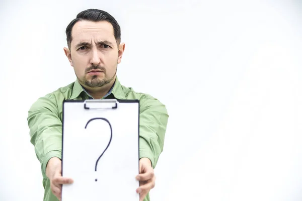 Perplexed businessman in casual clothes is showing a paper holder with question mark written on it, looking puzzled at the camera, asking for help. — Stock Photo, Image