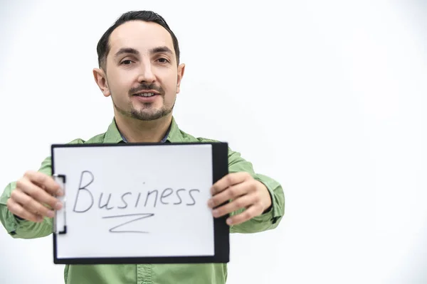 Brunette bearded man holding paper holder with word business writen on it, looking with comical face expression. — Stock Photo, Image