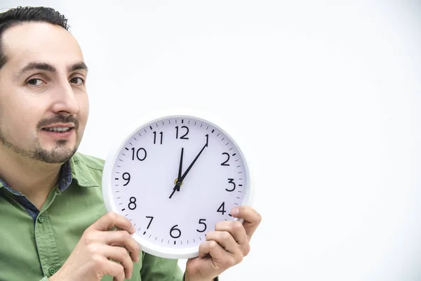 Retrato recortado del hombre en espera verde, sosteniendo el reloj sobre fondo blanco . —  Fotos de Stock