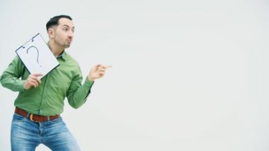 Elinde kağıt tutacağı olan komik dans eden genç adam üzerinde soru işareti olan bu işareti işaret ediyor..