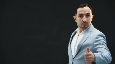 Münzevi neşeli genç adam başparmağını kaldırıyor, poz veriyor, aptalca hareket ediyor, flört ediyor..