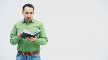 Adam ayakta duruyor, defterindeki verileri kontrol ediyor, iç çekiyor, yorgun görünüyor, sonra da öfkeyle bir kağıt parçasını yırtıyor, kitabı yere atıyor..