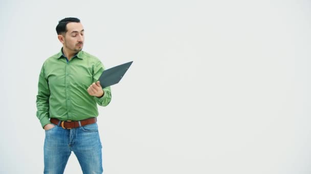 Vtipný mladý muž, který stojí a drží papírový držák se slovem "bisiness" na něm napsaným, ukazuje ho na kameru, ukazuje na něj, chová se komicky. — Stock video
