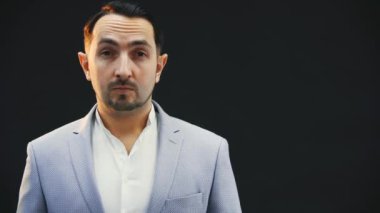 Ciddi bir şekilde konsantre olmuş genç adam yana bakıyor sonra kameraya bakıyor, poz veriyor..