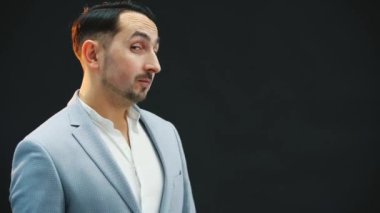 Komik genç adam ayakta duruyor, aklına yasak bir şey yapmayı getiriyor, parmaklarını vuruyor, ellerini ovuyor, aptal bir yüz ifadesi takınıyor..