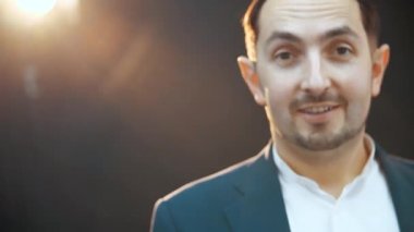 Ciddi genç işadamı ayakta duruyor, sonra kameraya bakıyor, poz veriyor, hareket ediyor..