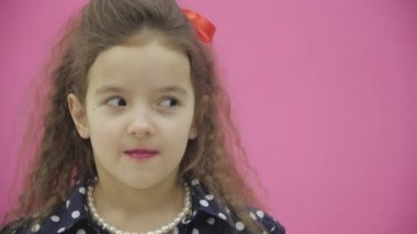 4k yavaş çekim videosunda küçük esmer bir kızın yakın çekimi var..