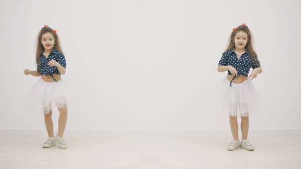 Portret tweeling Kaukasische meisjes dansen op de camera in 4k slowmotion video. — Stockvideo