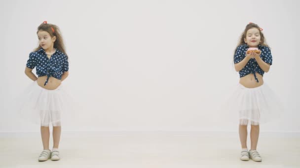 4k slow motion vídeo onde um gêmeo tem um donut rosa nas mãos e outro está apenas de pé. — Vídeo de Stock