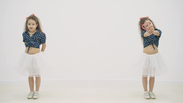 Dois belos jovens gêmeos femininos encaracolados fizeram um coração de pirulitos em vídeo de câmera lenta 4k . — Vídeo de Stock