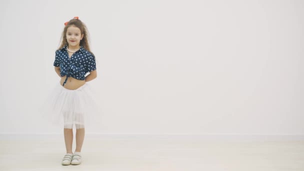 4k video di mana seorang gadis berpakaian polka dot bersembunyi di belakang punggung donat glazed. — Stok Video