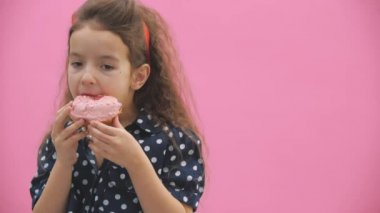 Küçük kız 4K videoda lezzetli çörekler yiyor..