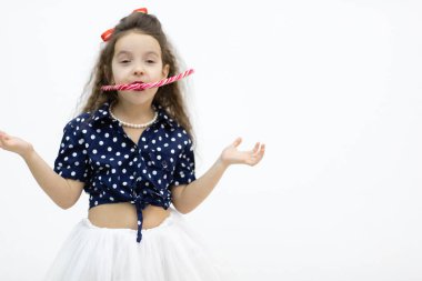 İki kırmızı lolipopu olan modaya uygun giyinmiş küçük bir kız..