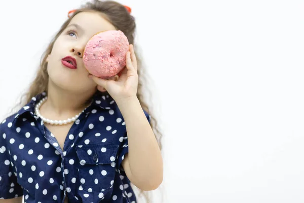 Kleines Mädchen versteckt sich hinter rosa Donut. — Stockfoto