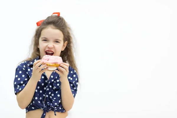 Kleines Mädchen mit glasiertem Donut in der Hand. — Stockfoto